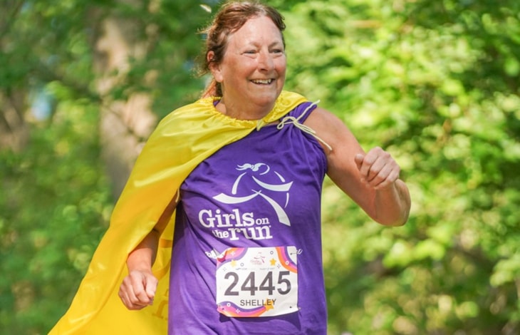 Coach Shelley running in her SuperCoach yellow cape which denotes her 20+ seasons of service! 